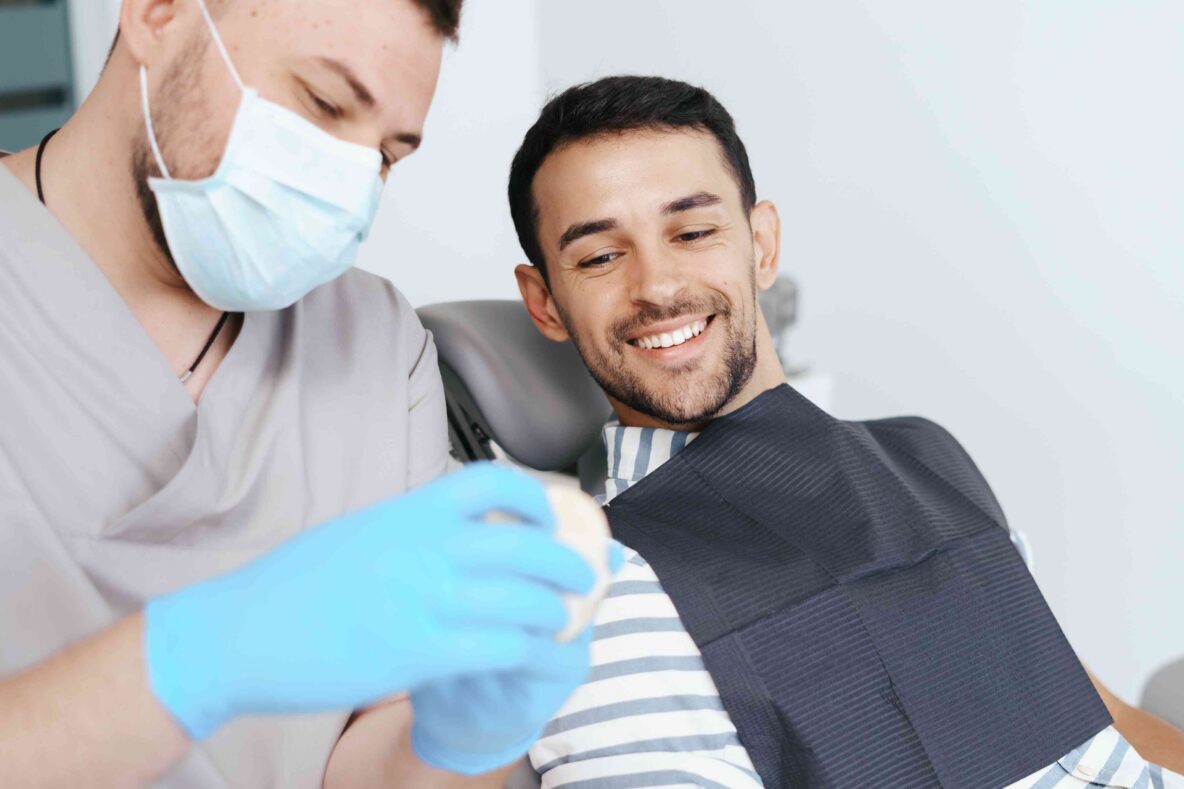 Smiling patient consulting with a dentist during a dental visit.